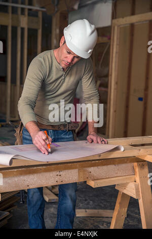 Engineer examining blueprint inside new structure Stock Photo