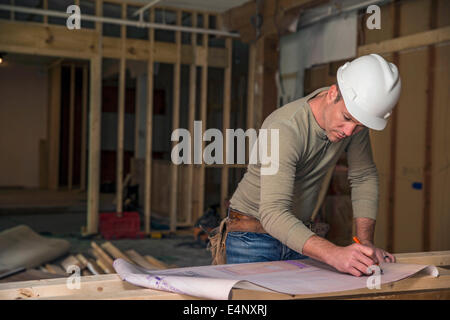 Engineer examining blueprint inside new structure Stock Photo