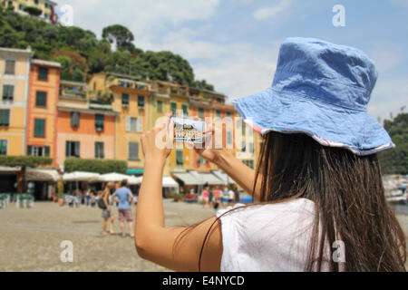 A woman tourist, photographing with mobile phone, Portofino, Cinque Terre, Italy Stock Photo