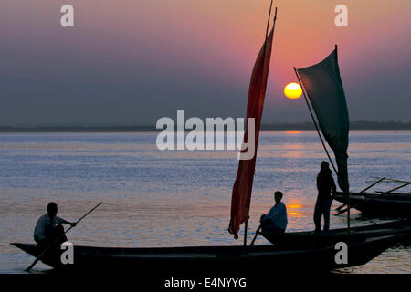 sunset in the river,sunset,moment,color,twilight,boat,sailboat,sail,red sail,water,bangladesh,in,padma,people,man,shilutthe,asia Stock Photo