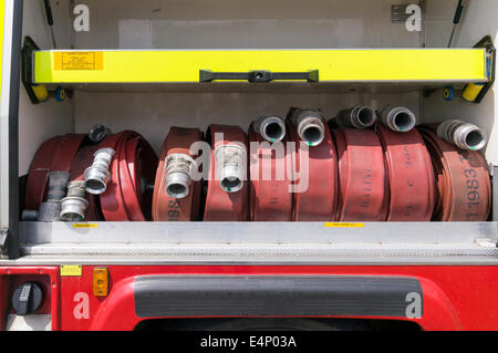 Coiled hoses stowed in a compartment on a UK fire brigade service emergency vehicle Stock Photo