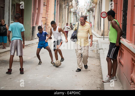 Boys playing with soccer ball in street, Havana, Cuba Stock Photo