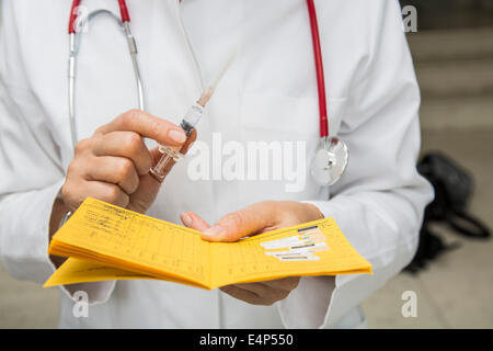 Vaccination certificate with syringe, disposable packaging, booster vaccination against diphtheria, tetanus and pertussis Stock Photo