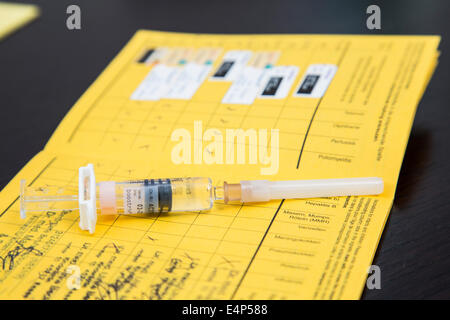 Vaccination certificate with syringe, disposable packaging, booster vaccination against diphtheria, tetanus and pertussis Stock Photo