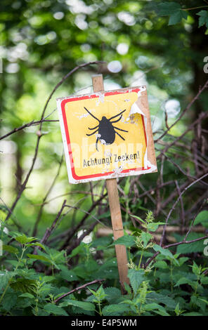 Sign in a forest, warns against ticks Stock Photo