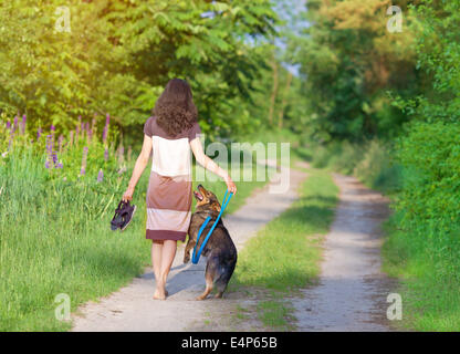 Young woman with dog walking in the village Stock Photo