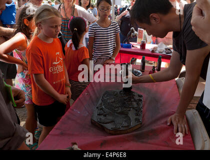 Man demonstrating Chinese woodblock printing at cultural festival - USA Stock Photo
