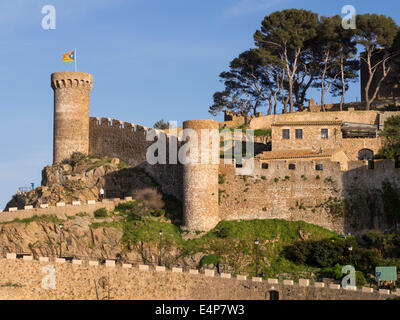 Fortress of Tossa de Mar topped by a Catalonian Flag. The massive stone defensive wall and tower of this coastal landmark Stock Photo