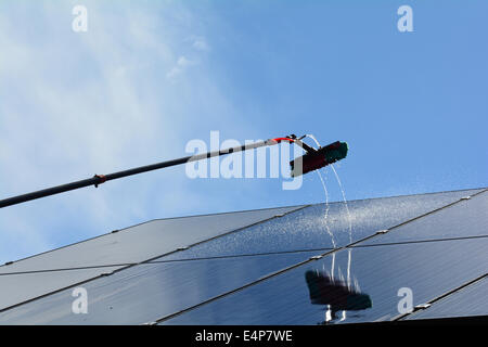 Solar panels on a residential property are cleaned using a high reach and wash water fed pole Stock Photo