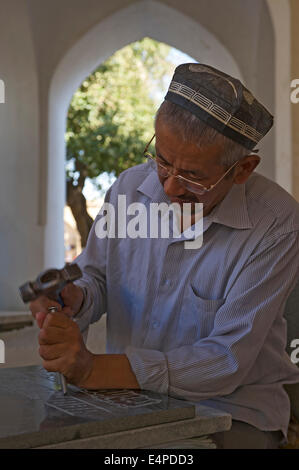 Stonemason chiselling a grave stone, Shakhrisabz, Shar-e Sabz or Shahrisabz, Uzbekistan Stock Photo