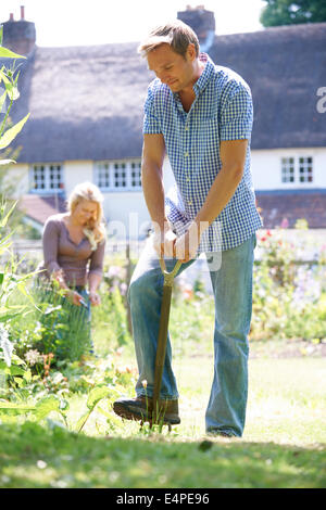 Couple Working In Garden At Home Together Stock Photo