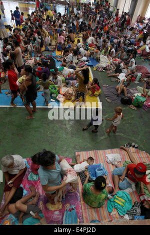 Manila, Philippines. 16th July, 2014. Residents take shelter in a covered court after evacuating from their homes as typhoon Rammasun batters Manila, the Philippines, July 16, 2014. At least 5 people were killed following the onslaught of typhoon Rammasun (local name: Glenda) which paralyzed the Philippine capital of Metro Manila on Wednesday. Credit:  Rouelle Umali/Xinhua/Alamy Live News Stock Photo