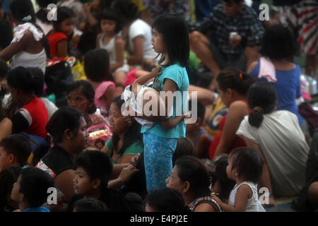 Manila, Philippines. 16th July, 2014. Residents take shelter in a covered court after evacuating from their homes as typhoon Rammasun batters Manila, the Philippines, July 16, 2014. At least 5 people were killed following the onslaught of typhoon Rammasun (local name: Glenda) which paralyzed the Philippine capital of Metro Manila on Wednesday. Credit:  Rouelle Umali/Xinhua/Alamy Live News Stock Photo
