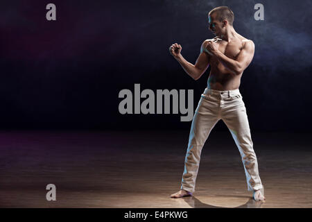 Young and muscular man ready to fight on a stage. Stock Photo