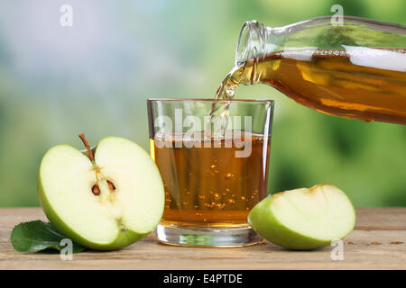 Apple juice pouring from green apples fruits in summer into a glass Stock Photo