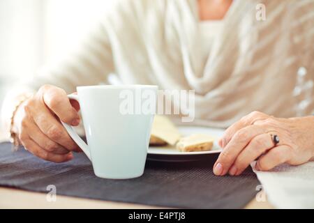 Closeup of a senior woman's hands with a cup of coffee Stock Photo