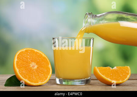 Fresh orange juice pouring into a glass in summer Stock Photo