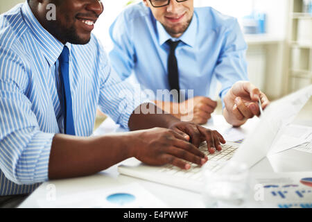 Image of two young businessmen discussing computer project at meeting Stock Photo