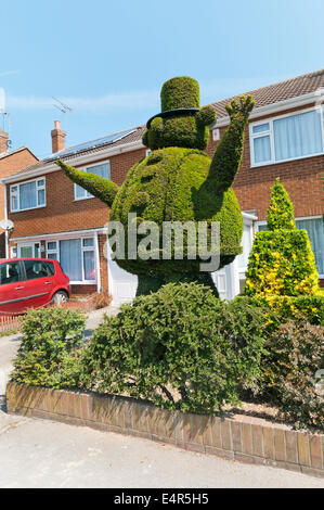 Topiary work of a large fat man in a hat in the front garden of a house in Broadstairs. Stock Photo