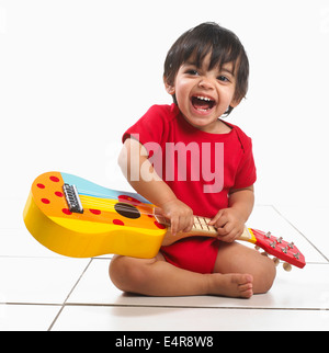 Small boy (16 months) with colourful guitar Stock Photo