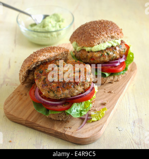 Spicy turkey burgers in wholemeal rolls, with avocado cream Stock Photo