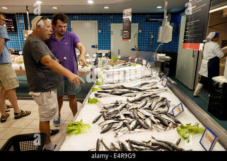 People shopping for sardines at the fish counter in a Portuguese supermarket, Lagoa, Portugal, Europe Stock Photo