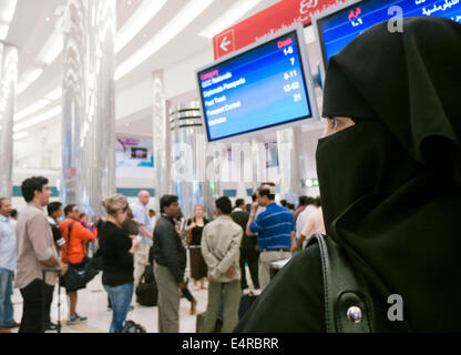 A muslim woman at Dubai International airport wearing a niqab Stock Photo