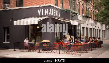 Patrons sit at the outdoor cafe of the Vinateria restaurant on Frederick Douglass Blvd in the neighborhood of Harlem in New York Stock Photo