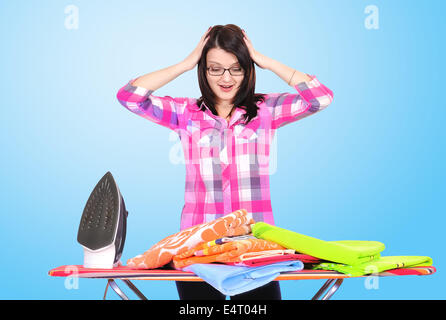 young girl ironing clothes on a blue background Stock Photo