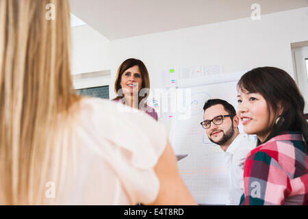 Mature businesswoman meeting and in discussion with group of young business people, Germany Stock Photo