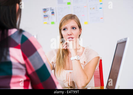 Two young businesswomen meeting and in discussion in office, Germany Stock Photo