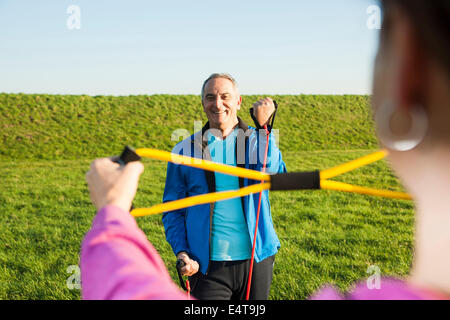Man and Woman Exercising with Resistance Band Outdoors, Baden-Wurttemberg, Germany Stock Photo