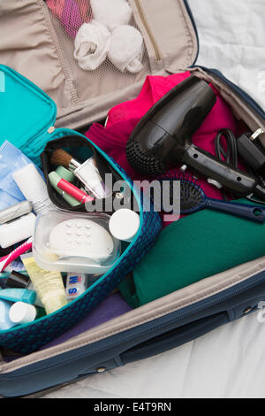 Women's Toiletry Travel Bag in Packed Suitcase Stock Photo