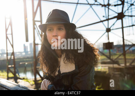 Portrait of teenage girl outdoors, wearing fedora and looking into the distance, Germany Stock Photo