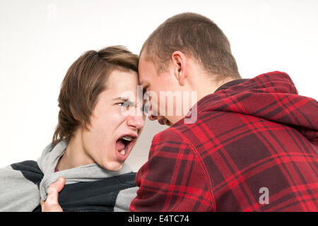 Close-up of two teenage boys fighting and screaming at each other, studio shot on white background Stock Photo