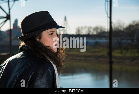 Close-up portrait of teenage girl outdoors, wearing fedora and looking into the distance, Germany Stock Photo