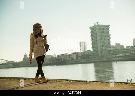 Teenage girl outdoors, walking along waterfront at loading dock, Mannheim, Germany Stock Photo