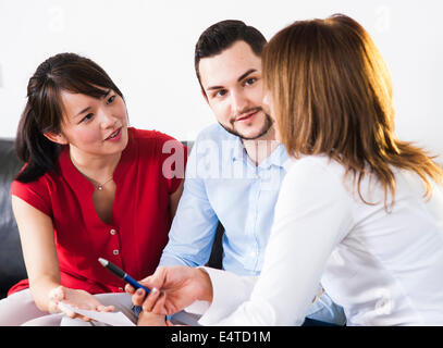 Backview of businesswoman in discussion with young couple, Germany Stock Photo
