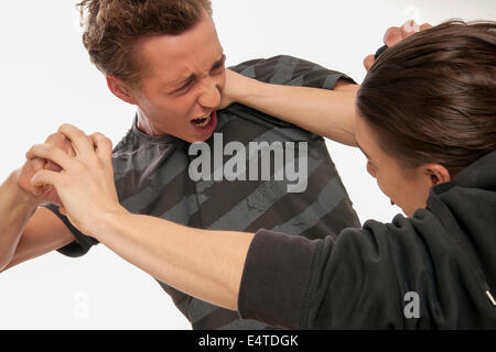 Close-up of two young men fighting, studio shot on white background Stock Photo