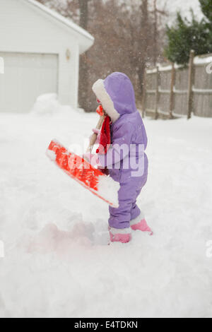 Toddler Girl Shoveling Snow, Maryland, USA Stock Photo