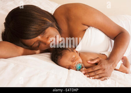Mother laying with Sleeping Newborn Baby