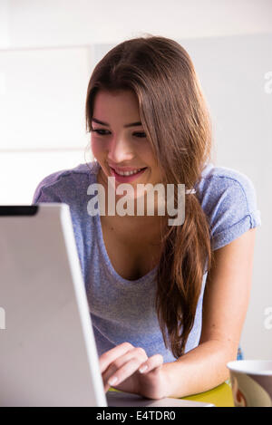 Close-up of young woman using laptop computer, working in office, studio shot