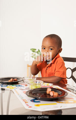 Boy Eating Lunch at Kitchen Table Stock Photo