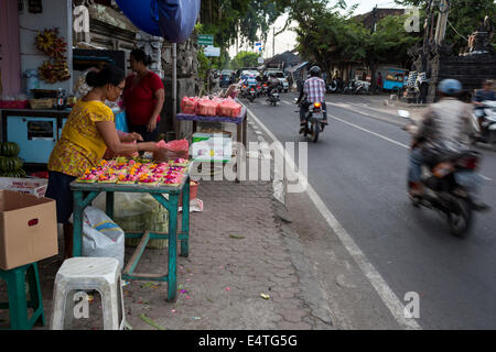Bali, Indonesia.  Religious offerings (canang) are made by an offerings specialist (tukang banten), to sell. Stock Photo