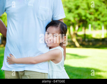 pretty little girl hug father waist in the park Stock Photo