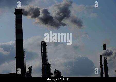 Feb. 9, 2014 - qingdao, CHN - 9, Feb, 2014. Qingdao, Shandong Province, China. After the snow, although it is Sunday, Chinese Sinopec Qingdao Refining and Chemical Co., Ltd. (Refinery) production is under way. Reporters see at the scene that tall chimneys emitting thick smoke, which cause severe air pollution. In 2013, part of the blown road cover debris that left since the 11.22 Sinope Qingdao Oil Pipeline Explosion was piled up on the Refinery's second phase vacant area. And the Zhang Gezhuang community, which is just across the road, is being demolished. Because of the Spring Festival, t Stock Photo