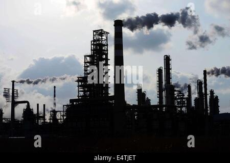 Feb. 9, 2014 - qingdao, CHN - 9, Feb, 2014. Qingdao, Shandong Province, China. After the snow, although it is Sunday, Chinese Sinopec Qingdao Refining and Chemical Co., Ltd. (Refinery) production is under way. Reporters see at the scene that tall chimneys emitting thick smoke, which cause severe air pollution. In 2013, part of the blown road cover debris that left since the 11.22 Sinope Qingdao Oil Pipeline Explosion was piled up on the Refinery's second phase vacant area. And the Zhang Gezhuang community, which is just across the road, is being demolished. Because of the Spring Festival, t Stock Photo