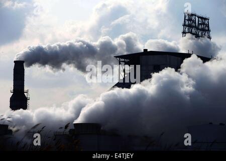 Feb. 9, 2014 - qingdao, CHN - 9, Feb, 2014. Qingdao, Shandong Province, China. After the snow, although it is Sunday, Chinese Sinopec Qingdao Refining and Chemical Co., Ltd. (Refinery) production is under way. Reporters see at the scene that tall chimneys emitting thick smoke, which cause severe air pollution. In 2013, part of the blown road cover debris that left since the 11.22 Sinope Qingdao Oil Pipeline Explosion was piled up on the Refinery's second phase vacant area. And the Zhang Gezhuang community, which is just across the road, is being demolished. Because of the Spring Festival, t Stock Photo