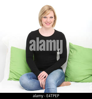 Pretty relaxed woman sitting on a couch Stock Photo