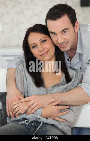 Couple sat on sofa together Stock Photo